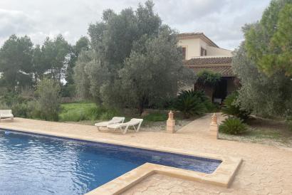 Country house with a stone façade, pool, and olive plantation in Llucmajor.